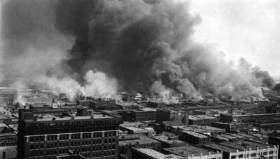 2006.75.01 Says on back
Burning of "Little Africa" the negro sction of Tulsa, OK during the race riot, June 1, 1921. About 30 were slain, 9 white, the balance negroes. This picture taken from the roof of the Cosden Building, 14 stories.